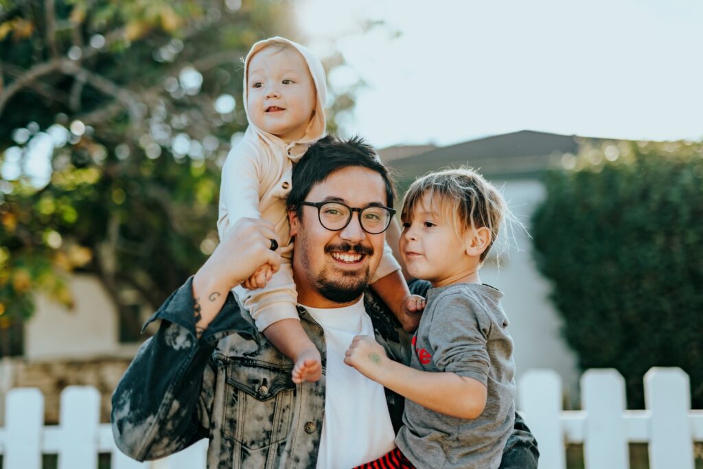 Man with family in front of house
